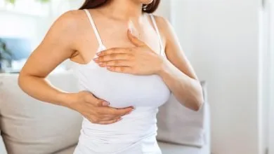 mujer joven realizando el autoexamen de seno para detectar los primeros síntomas del cáncer de mama / desodorantes de aerosol