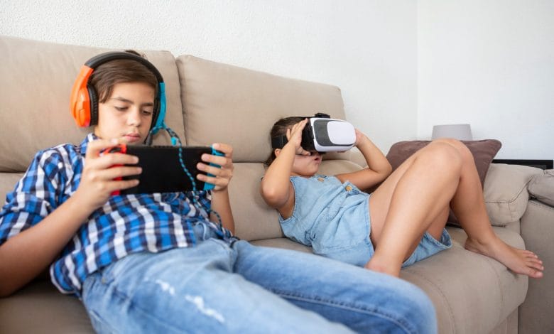 niños con adicción a los videojuegos jugando en un sofá