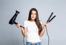 Mujer cuestionándose sobre el uso de secadores y planchas para el cabello