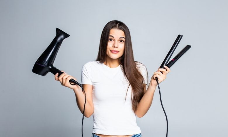 Mujer cuestionándose sobre el uso de secadores y planchas para el cabello