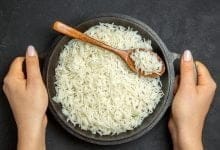 arroz cocido dentro de la sartén en la superficie oscura - arroz todos los días