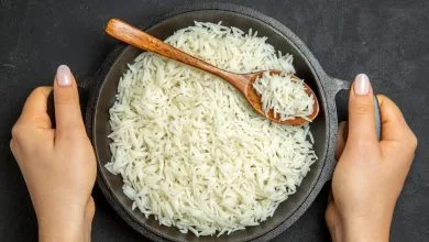 arroz cocido dentro de la sartén en la superficie oscura - arroz todos los días